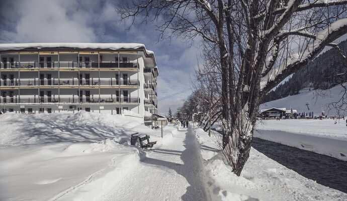 Winterwanderweg entlang des Landwassertal, im Hintergrund ein mehrstöckiges Gebäude | © Davos Klosters Mountains 