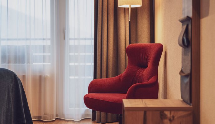 Lounge chair with lounge table, window and curtains | © Davos Klosters Mountains 